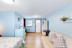 una camera da letto con pareti blu, un divano e un tavolo di Breakwater Inn - Towhee Cottage #F a Grayland