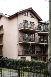 an apartment building with balconies and a fence at Villa Pasja in Świnoujście