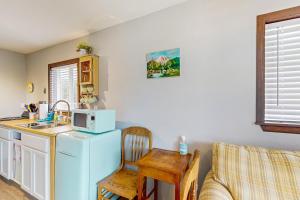 a kitchen with a refrigerator and a table and a chair at Breakwater Inn - Bulfinch Condo #5 in Grayland