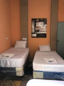 dwa łóżka siedzące obok siebie w pokoju w obiekcie Hotel Brunette w mieście Santa Ana