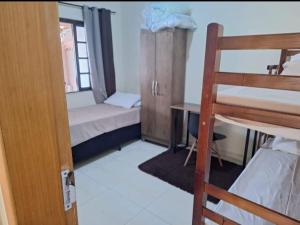 um pequeno dormitório com um beliche e uma escada em Kitnets Dona Lucia SJC em São José dos Campos