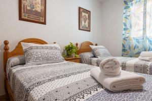 - une chambre avec 2 lits avec un chapeau dans l'établissement Apartamento moderno en pleno centro Granada, à Grenade