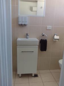 a bathroom with a white sink and a mirror at Forster and Wallis Lake Motel in Forster