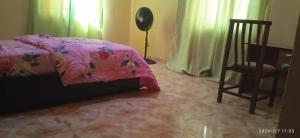 una camera da letto con un letto rosa e una sedia di Next2home a Sango Otta Altre 7 foto