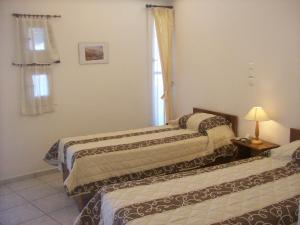 a room with two beds and a window at Vassiliki Studios in Andros
