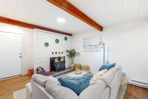 sala de estar con sofá y chimenea en Breakwater Inn - Cranberry Cottage #A, en Grayland