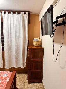 a room with a tv and a dresser with a curtain at Apart Centro- VICTORIA555 in Libertador General San Martín