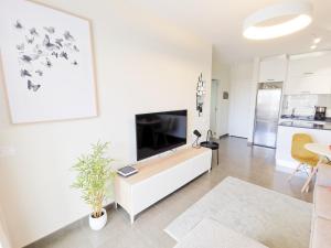 a living room with a large flat screen tv at Iguazu 210 Stylish Home By Pride Holiday Rentals in Maspalomas