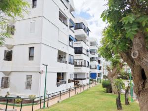 an apartment building with balconies and a tree at Iguazu 210 Stylish Home By Pride Holiday Rentals in Maspalomas