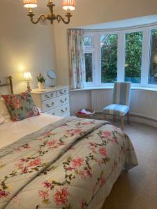 a bedroom with a bed and a chair and windows at Mariners Corner in Bexhill