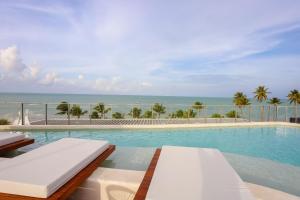 a swimming pool with a view of the ocean at Setai Yacht Premium - By Almare Flats in João Pessoa
