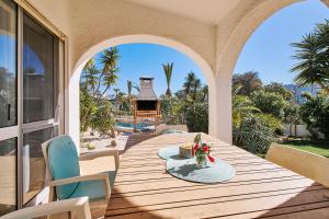 une table et des chaises sur une terrasse avec une cheminée dans l'établissement Do Jardim, à Carvoeiro