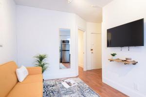 a living room with a couch and a tv on a wall at 69-5D Modern Lower East East 1br Apt BRAND NEW in New York