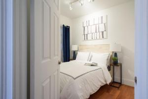 a bedroom with a bed with white sheets and a window at 69-5D Modern Lower East East 1br Apt BRAND NEW in New York