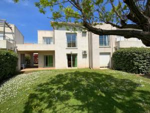 a large white house with a large grass yard at Rez de Jardin Piscine et Plage in Poggio-Mezzana