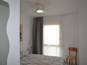 une chambre avec un lit, une fenêtre et une chaise dans l'établissement Nautica - L'Estartit, Centro - ES-323-84, à L'Estartit