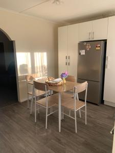 a kitchen with a table and chairs and a refrigerator at The Homestead - cosy 3 bedroom house in Rotorua