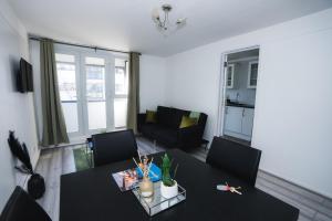 sala de estar con mesa negra y sillas en 1 Bed Flat Tottenham Hale N17 en Londres