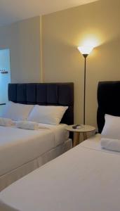 um quarto de hotel com duas camas e um candeeiro em Pousada Himura em Angra dos Reis