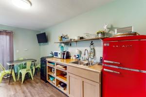uma cozinha com um frigorífico vermelho e uma mesa em Breakwater Inn - King Cyrus Condo #9 em Grayland