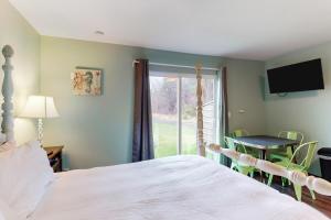 um quarto com uma cama, uma mesa e uma janela em Breakwater Inn - King Cyrus Condo #9 em Grayland