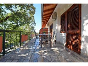 a balcony of a house with a table and chairs at Apartments and Room Adriana in Starigrad