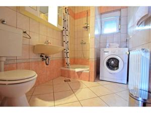 a bathroom with a toilet and a washing machine at Apartments and Room Adriana in Starigrad
