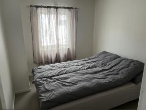 an unmade bed in a bedroom with a window at Helt hus: Sneveien 75 in Bodø