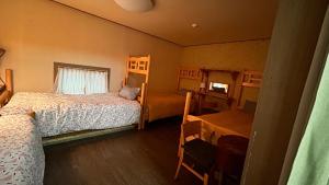 1 dormitorio con 2 camas, mesa y ventana en Gyeongju Momojane Guesthouse, en Gyeongju
