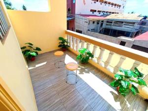 Chic Appart Climatisé Wifi 1er Etage في لوميه: شرفة مع كرسيين و نباتات على مبنى