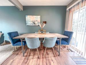 uma sala de jantar com uma mesa de madeira e cadeiras azuis em New 3 bd 2 bath Hot tub em Omaha