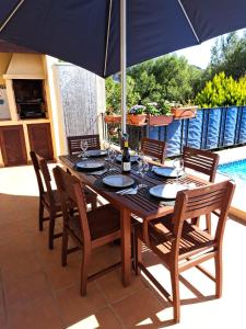 a wooden table with chairs and an umbrella on a patio at Sweet Home in Pego
