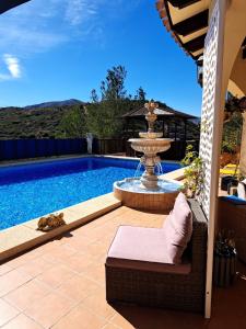 a swimming pool with a fountain and a chair next to it at Sweet Home in Pego +13 photos