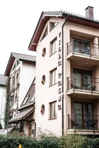 a white building with a sign on it at Villa Pasja in Świnoujście