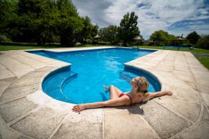 a young girl laying in a swimming pool at Cabañas Ocho Soles in Las Rabonas