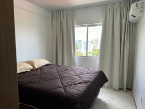 a bedroom with a bed and a large window at Apartamento com mobília nova 301 in Francisco Beltrão