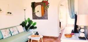 ein Wohnzimmer mit einem grünen Sofa und einem Spiegel in der Unterkunft Appartement Rosa (Albox) in Albox