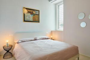 Biała sypialnia z dużym łóżkiem i 2 świecami w obiekcie Relais al Teatro w mieście Chieti