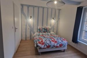 1 Schlafzimmer mit einem Bett mit Blumendecke in der Unterkunft Le Prieuré - 4 chambres ensuite (avec salles de bain privative) in Harfleur