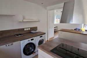eine Küche mit Waschmaschine und Trockner auf der Theke in der Unterkunft Le Prieuré - 4 chambres ensuite (avec salles de bain privative) in Harfleur