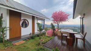 a balcony of a house with a table and chairs at Sirine​ Onsen​ รีสอร์ทออนเซนวิวทะเลหมอก in Khao Kho