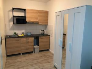 uma cozinha com armários de madeira e uma bancada em Motel de Winter - Motel - Apartmenthaus - Monteurzimmer em Castrop-Rauxel
