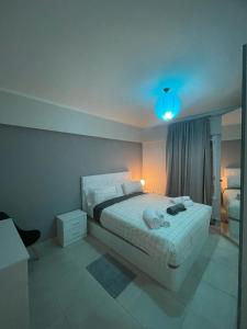 1 dormitorio con cama blanca y luz azul en Oasis del sur, sea view los cristianos, en Los Cristianos