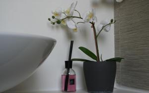 a black vase with white flowers and a bottle of perfume at Bamboo Luxury Agrigento in Agrigento +43 photos