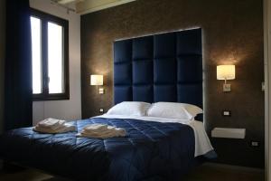 a bedroom with a blue bed with two towels on it at Bamboo Luxury Agrigento in Agrigento