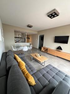 a living room with a large couch and a table at BRISApartament a cuadras del mar, moderno y confortable in Puerto Madryn