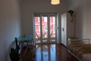 a room with a bed and a table and a sliding glass door at Alvalade SkyView CoLiving in Lisbon