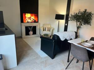 a living room with a fireplace and a table and chairs at Privatunterkunft in Gronau in Spechtholzhock