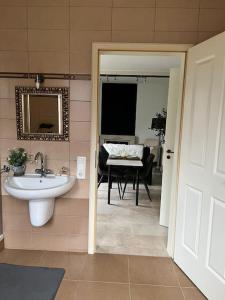 a bathroom with a sink and a mirror and a table at Privatunterkunft in Gronau in Spechtholzhock