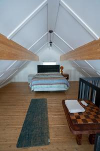 een slaapkamer op zolder met een bed en een schaakbord op de vloer bij Bord de l'eau Maison toit Cathédrale Fenestré in Sainte-Félicité